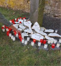 Gedenkstein Drogengebraucher mit Hand die Kerze hinstellt