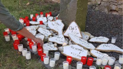 Gedenkstein Drogengebraucher mit Hand die Kerze hinstellt